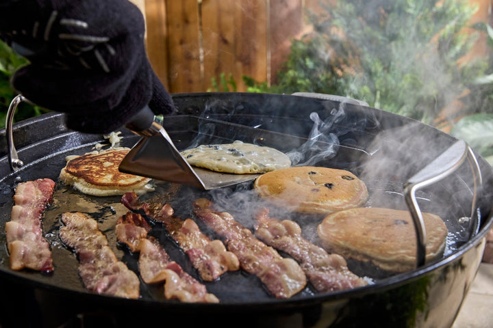 Breakfast cooking on a Weber Full-Size Griddle on charcoal BBQ