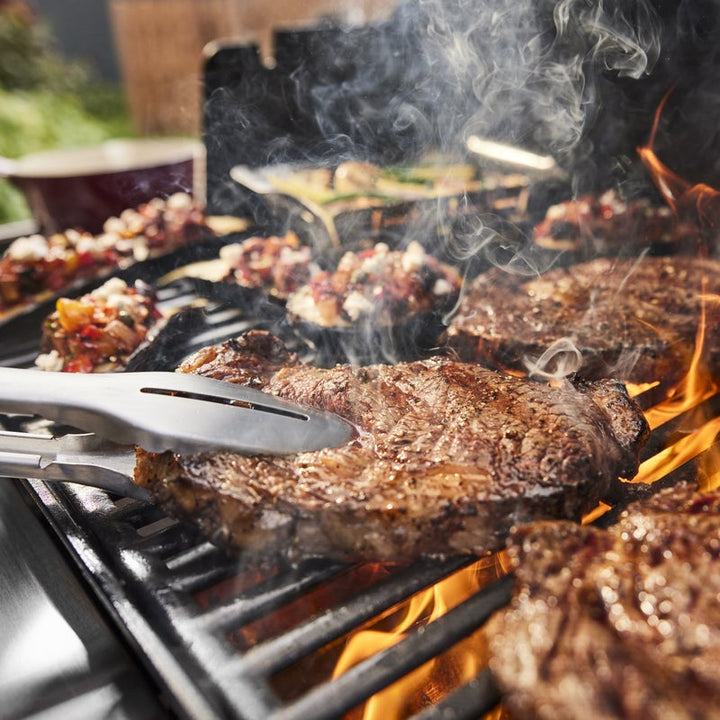 Steaks cooking on Weber genesis grill grates